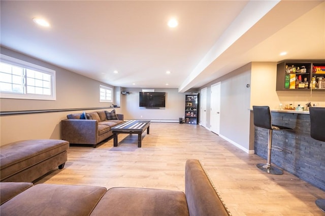 living room with bar and light wood-type flooring