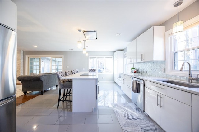 kitchen with hanging light fixtures, stainless steel appliances, and white cabinets