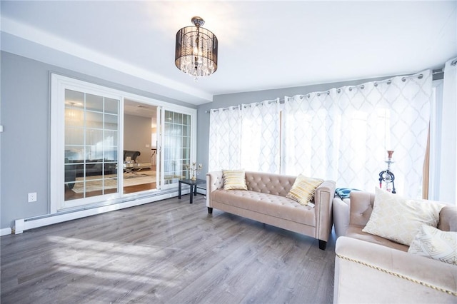 living room featuring hardwood / wood-style flooring, a baseboard radiator, and a chandelier