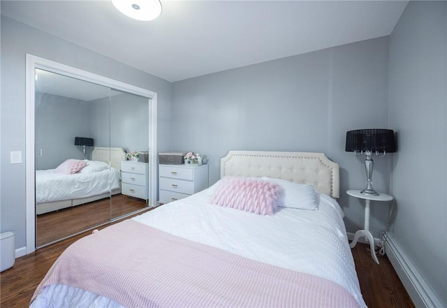 bedroom featuring dark hardwood / wood-style flooring, a closet, and baseboard heating