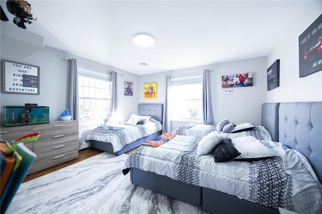 bedroom featuring multiple windows and dark wood-type flooring