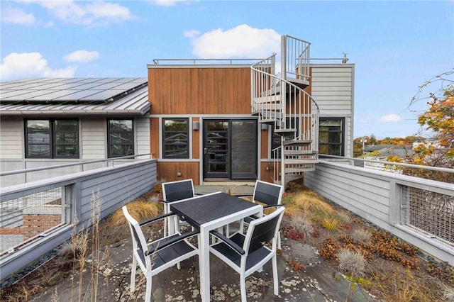 back of house featuring solar panels