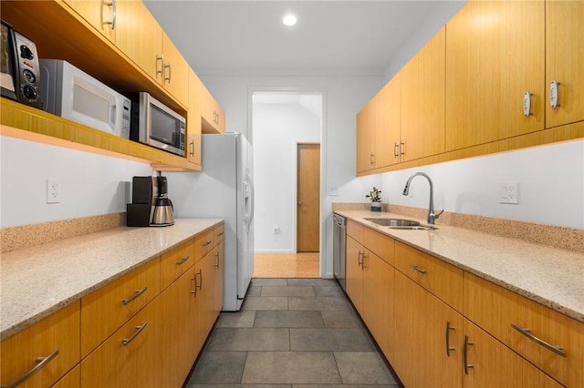 kitchen featuring sink, stainless steel appliances, dark tile patterned flooring, and light stone countertops