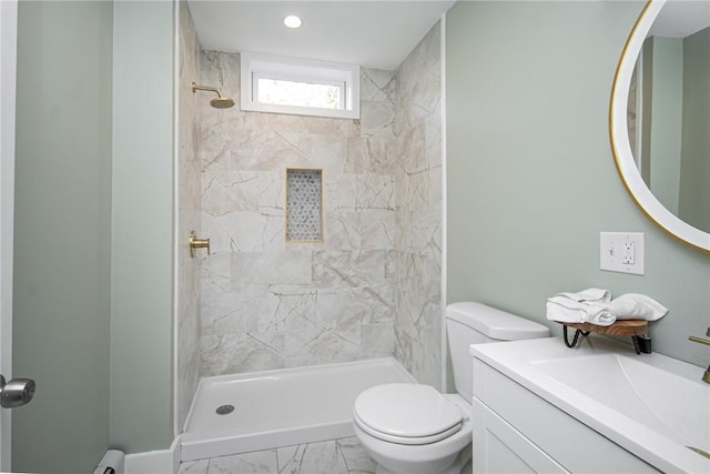 bathroom with vanity, toilet, and tiled shower