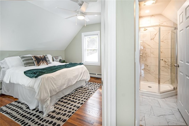 bedroom featuring ensuite bath, vaulted ceiling, light wood-type flooring, ceiling fan, and a baseboard heating unit