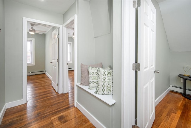 hall featuring baseboard heating, lofted ceiling, and dark hardwood / wood-style floors