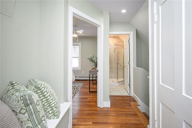 hall featuring a baseboard heating unit and wood-type flooring