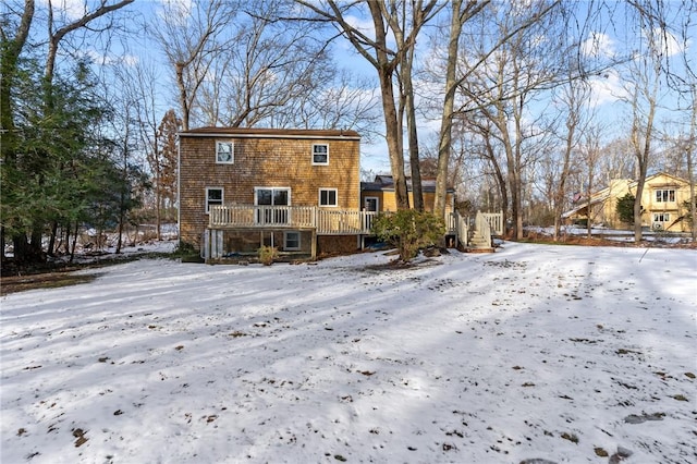 snow covered house with a wooden deck