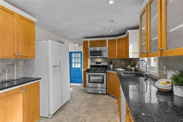 kitchen with tasteful backsplash, sink, stainless steel appliances, and dark stone counters