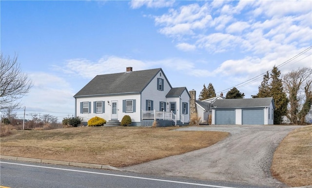 view of front of house featuring a garage, an outdoor structure, covered porch, and a front yard