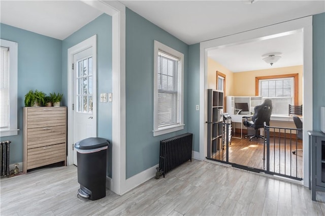 entrance foyer with radiator heating unit, wood finished floors, and baseboards