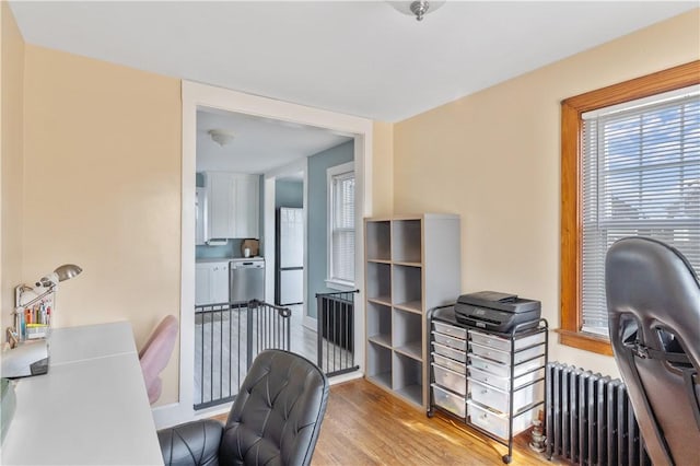 office space featuring radiator heating unit and light hardwood / wood-style floors