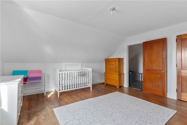 unfurnished bedroom featuring vaulted ceiling and dark wood-type flooring