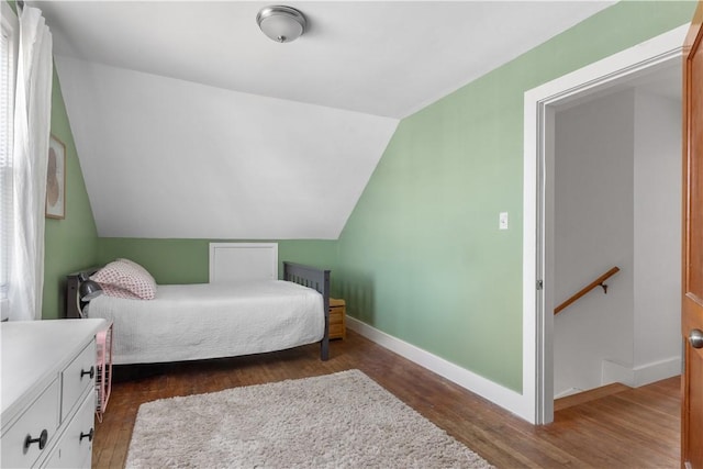 bedroom with vaulted ceiling and dark hardwood / wood-style floors