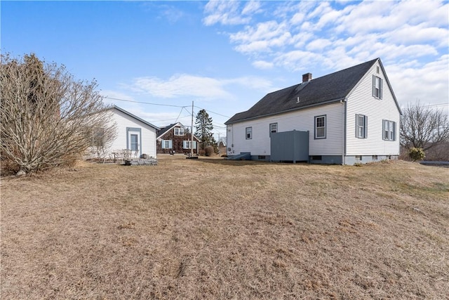 back of property featuring a yard and a chimney