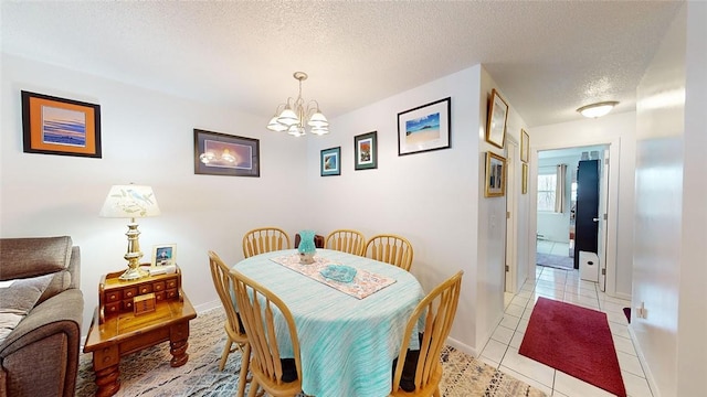 tiled dining space featuring a notable chandelier and a textured ceiling