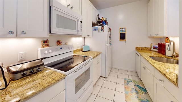 kitchen featuring sink, white appliances, light stone countertops, and white cabinets