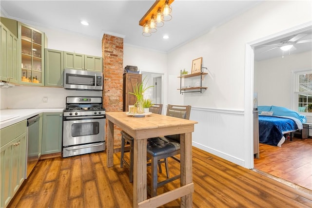 kitchen featuring stainless steel appliances, ornamental molding, dark hardwood / wood-style floors, and green cabinets