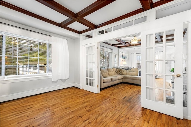 unfurnished sunroom featuring coffered ceiling, a wealth of natural light, and beamed ceiling