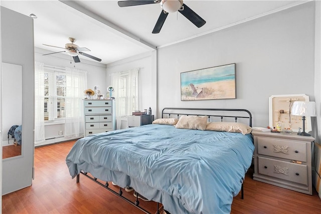 bedroom with a baseboard radiator, ornamental molding, hardwood / wood-style floors, and ceiling fan