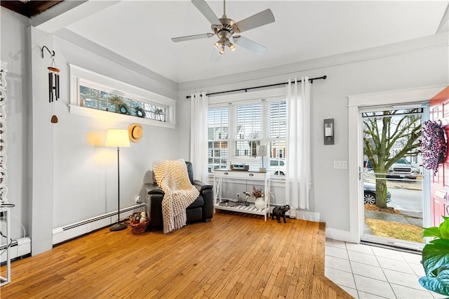 sitting room featuring a baseboard radiator, a healthy amount of sunlight, and light hardwood / wood-style flooring