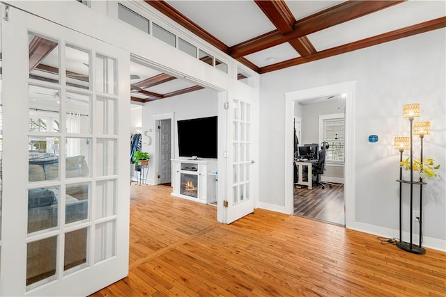 unfurnished living room with hardwood / wood-style flooring, coffered ceiling, and beam ceiling