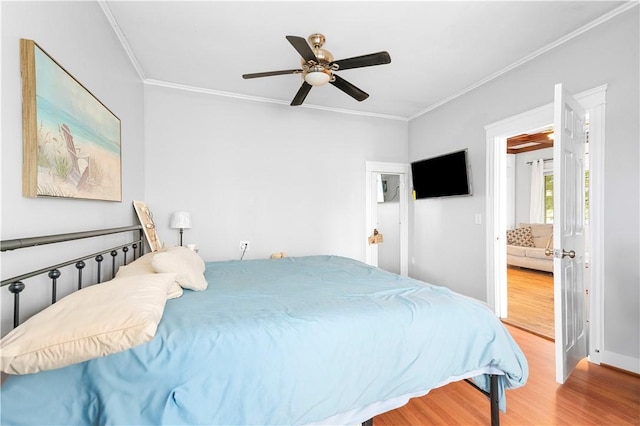 bedroom with hardwood / wood-style flooring, ceiling fan, and ornamental molding