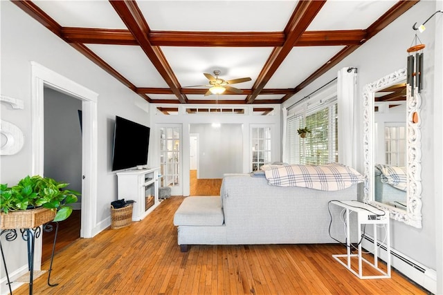 living room featuring coffered ceiling, beamed ceiling, ceiling fan, light hardwood / wood-style floors, and a baseboard heating unit