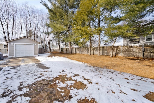 yard layered in snow with a garage and an outbuilding