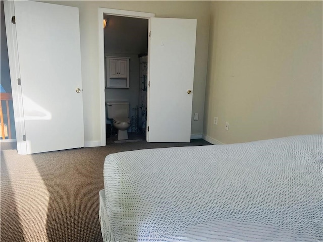 bedroom featuring dark carpet and ensuite bath