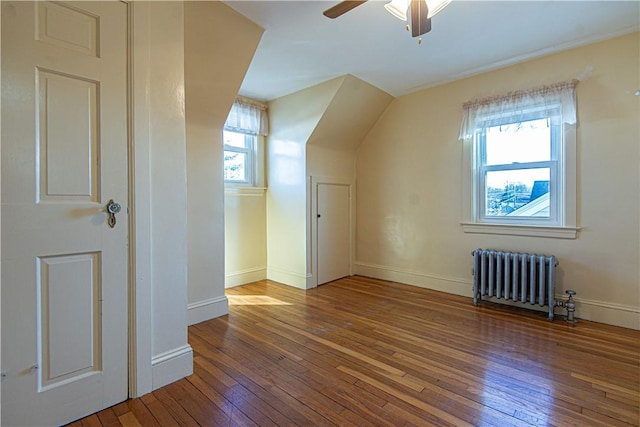 bonus room featuring ceiling fan, radiator heating unit, vaulted ceiling, and wood-type flooring