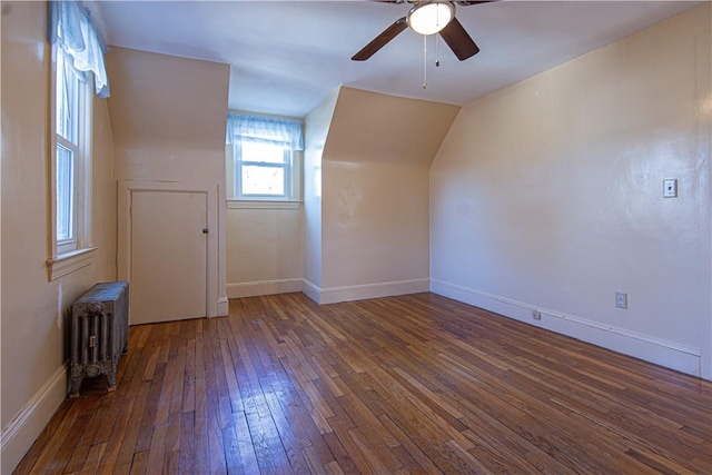 additional living space featuring ceiling fan, lofted ceiling, dark hardwood / wood-style flooring, and radiator