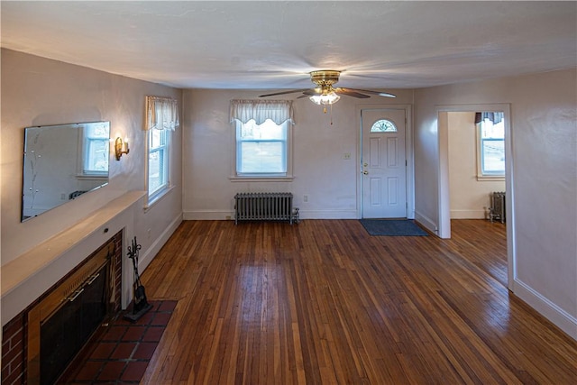 unfurnished living room with ceiling fan, radiator, and dark hardwood / wood-style floors