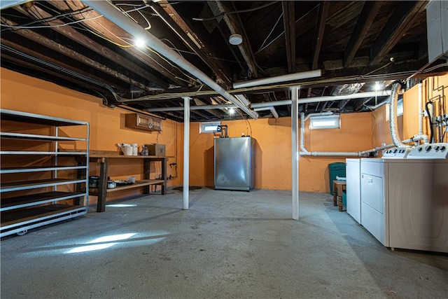 basement featuring washing machine and dryer and refrigerator