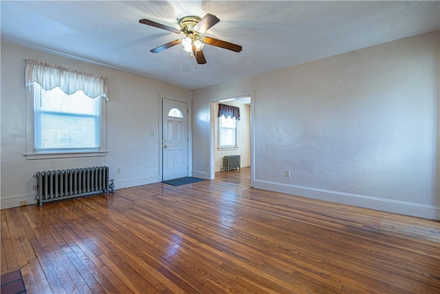 interior space featuring dark wood-type flooring, radiator heating unit, and ceiling fan