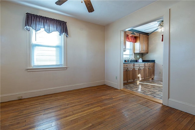 unfurnished dining area with sink, dark wood-type flooring, and ceiling fan