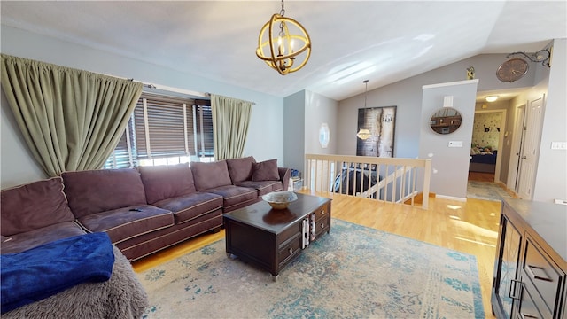 living room featuring lofted ceiling, a notable chandelier, and light wood finished floors