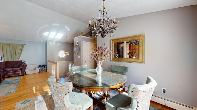 dining area with a baseboard heating unit, vaulted ceiling, an inviting chandelier, and wood finished floors