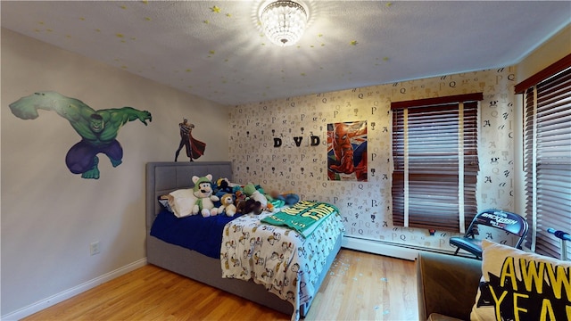 bedroom with wallpapered walls, baseboards, and wood finished floors