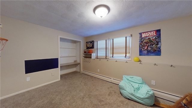 unfurnished bedroom with a baseboard heating unit, carpet, a textured ceiling, and baseboards