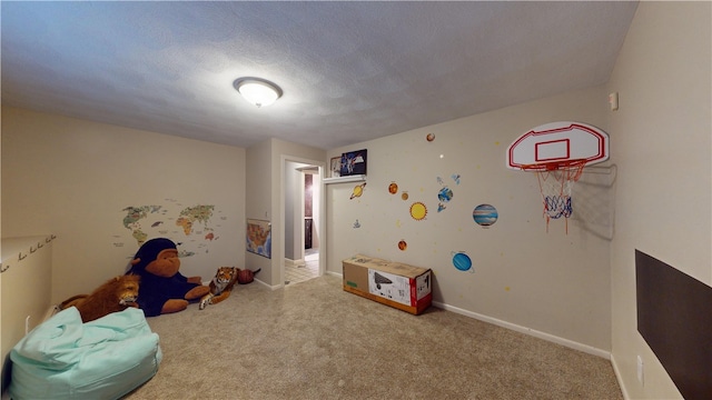 rec room featuring a textured ceiling, carpet, and baseboards