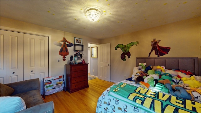 bedroom with a closet, baseboards, and light wood finished floors