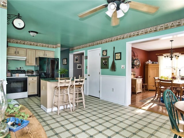 kitchen featuring hanging light fixtures, electric range, cream cabinets, a kitchen bar, and black fridge with ice dispenser