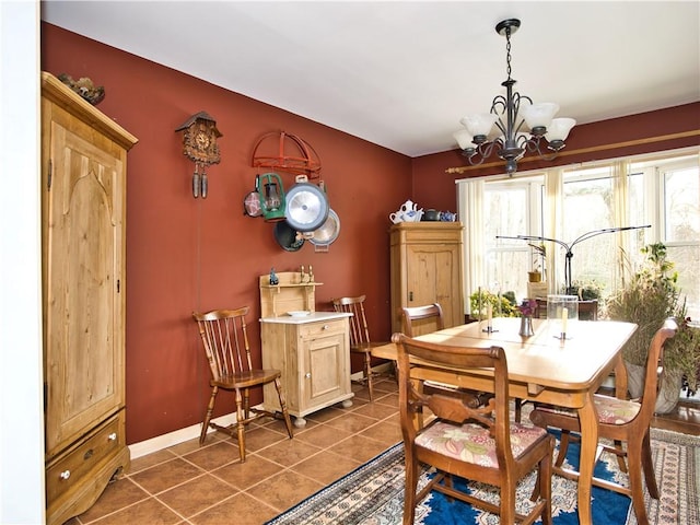 dining space featuring a healthy amount of sunlight, a chandelier, and dark tile patterned floors