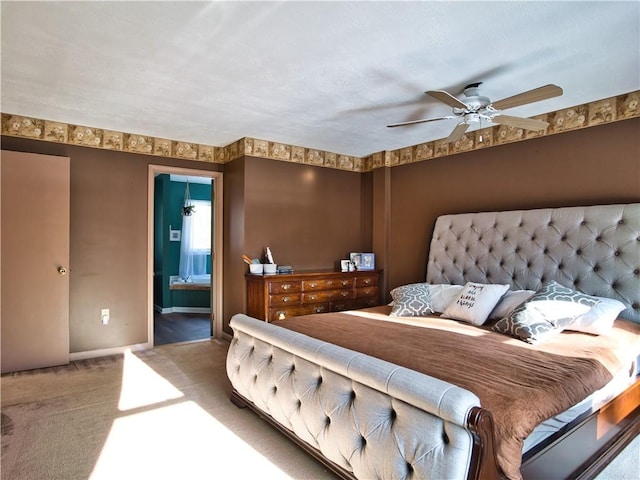 bedroom featuring ensuite bathroom, carpet flooring, and ceiling fan