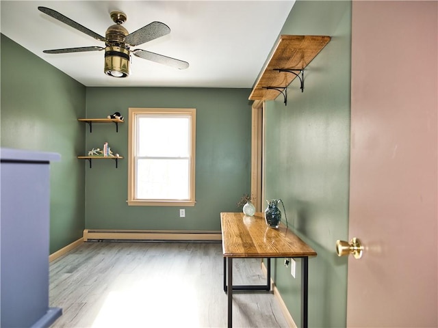 doorway to outside with ceiling fan, a baseboard radiator, and light hardwood / wood-style flooring