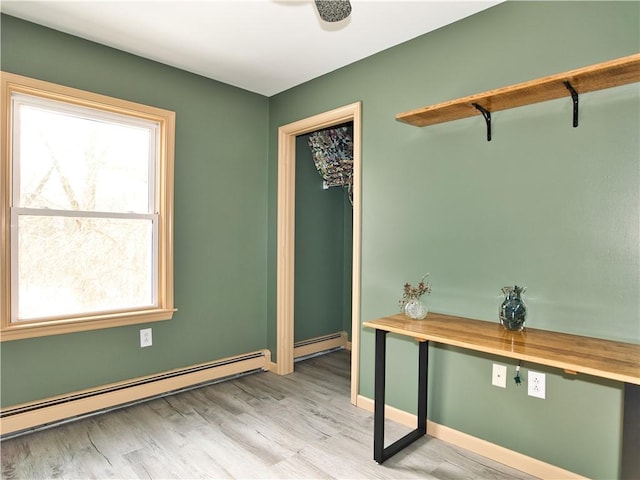 interior space featuring a baseboard radiator, plenty of natural light, and light hardwood / wood-style floors