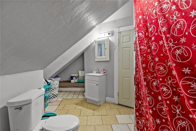 bathroom featuring lofted ceiling, tile patterned flooring, vanity, toilet, and a textured ceiling