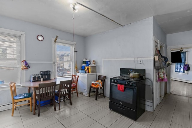 kitchen with a baseboard radiator, refrigerator, and black gas range