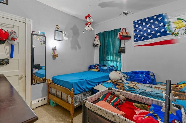 bedroom with carpet floors and a baseboard heating unit